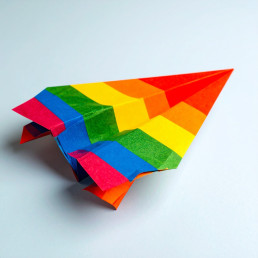 Avion en papier aux couleurs de l'arc-en-ciel