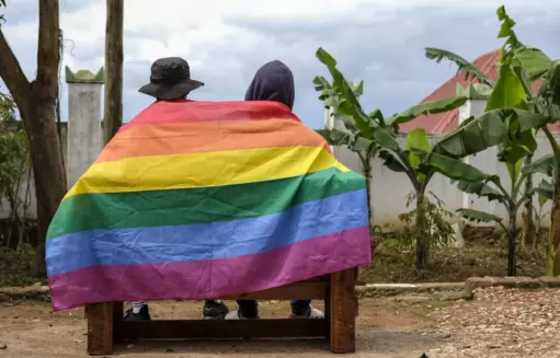 Un couple d’homosexuels ougandais arbore le drapeau de la fierté gaie